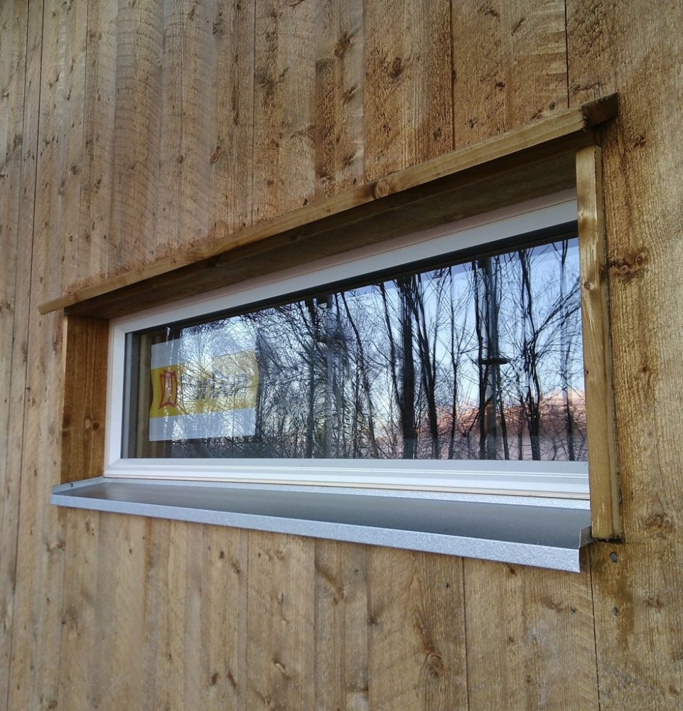 Långsmalt fönster med droppnäsa av trä och aluzinkbleck.
